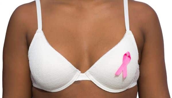 Mulher negra expõe fita rosa referente ao outubro rosa no sutiã branco - Prevenção ao câncer de mama.