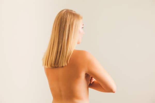 mulher com as costas nuas e bonitas após lipoaspiração na região